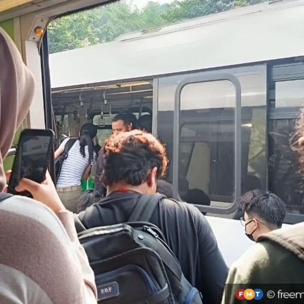 Passengers being moved to another train following the power outage which left their train stranded on the tracks.