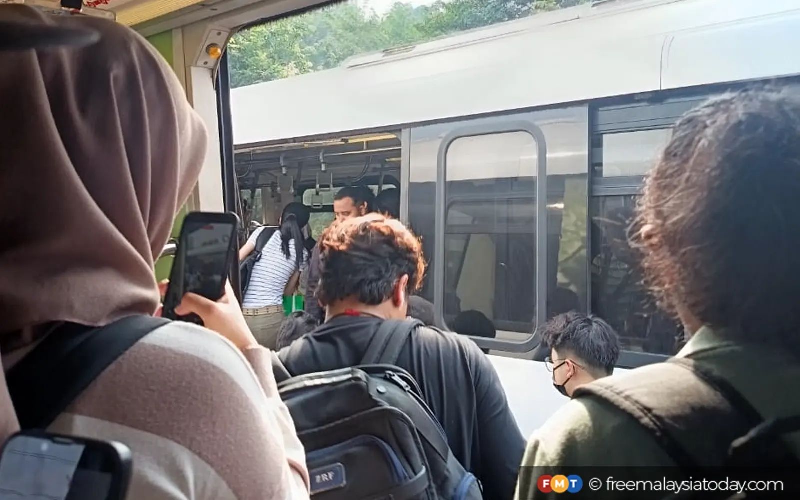 Passengers being moved to another train following the power outage which left their train stranded on the tracks.