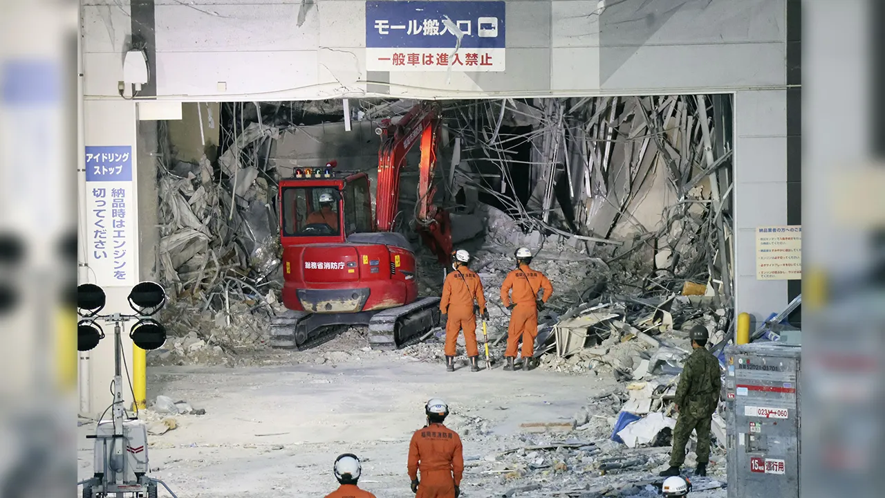 Heavy machinery clearing rubble at the quake- and blast-damaged Aeon Mall in Kashima, Kumamoto